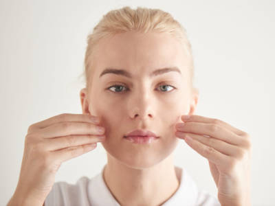 donna ragazza zigomi mani viso