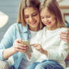 bambina ragazza divano sorriso smartphone cellulare
