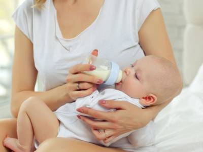 Mamma allatta con biberon neonato