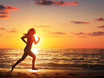 Donna corsa sulla spiaggia tramonto