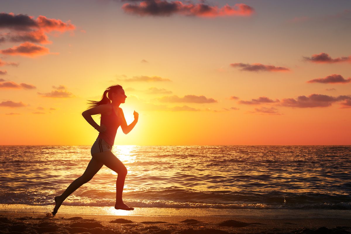 Donna corsa sulla spiaggia tramonto