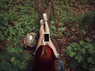 Ragazza con lo smartphone nella natura