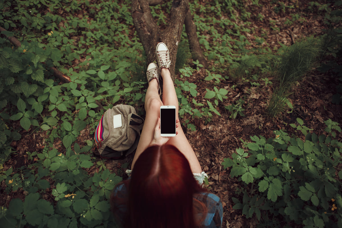 Ragazza con lo smartphone nella natura