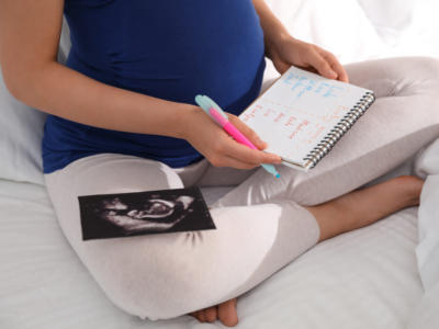 Donna incinta con lista di nomi di bambini