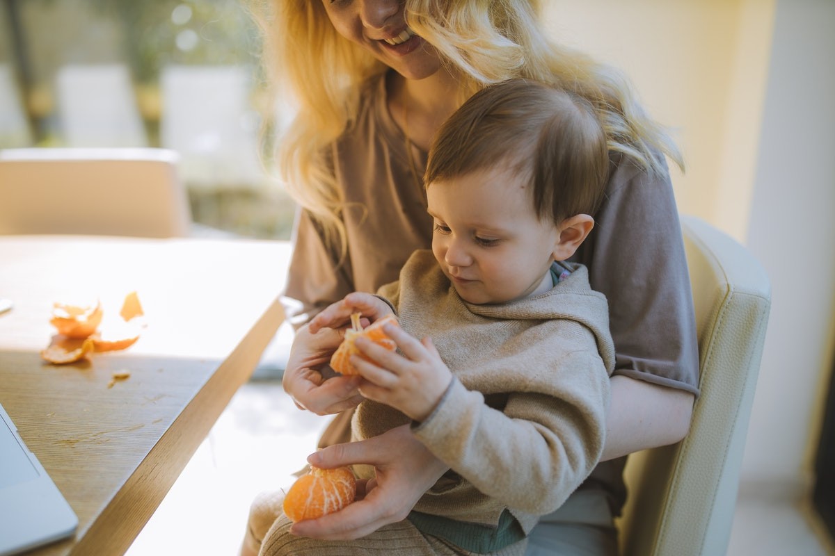 Bambino che mangia un'arancia