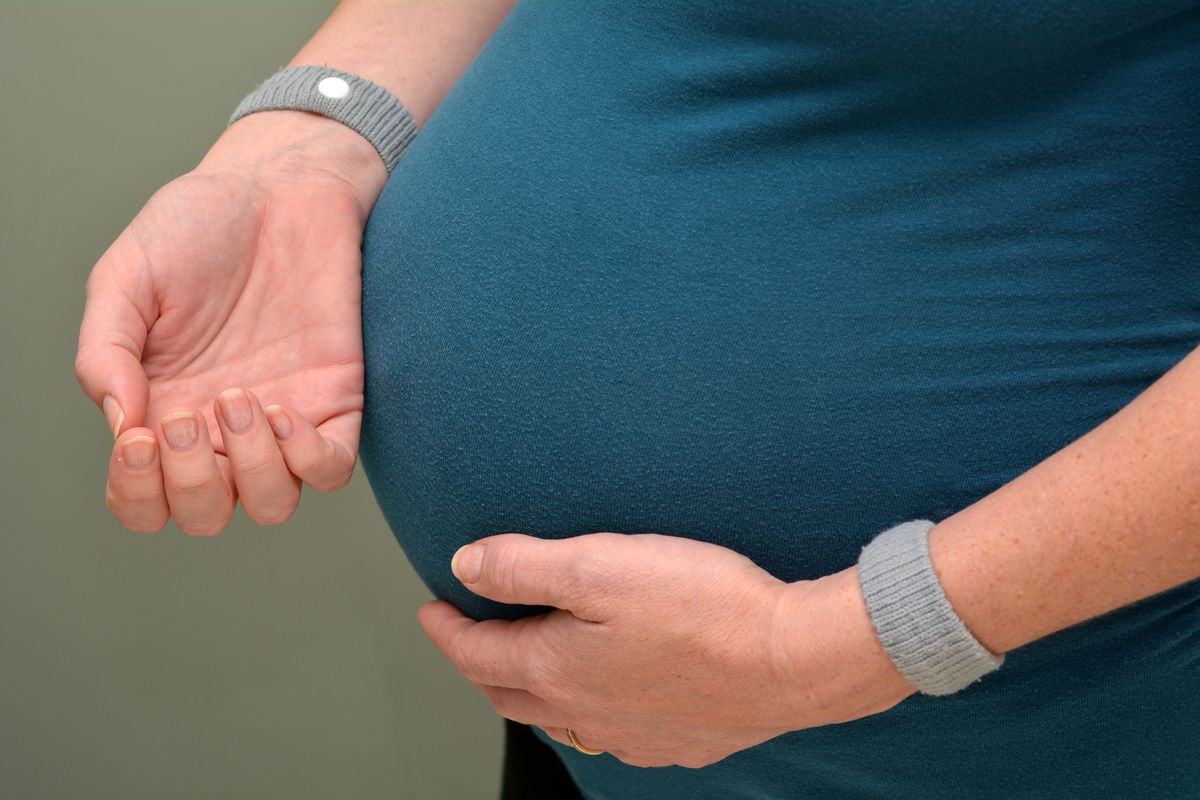 Donna incinta che indossa braccialetti antinausea
