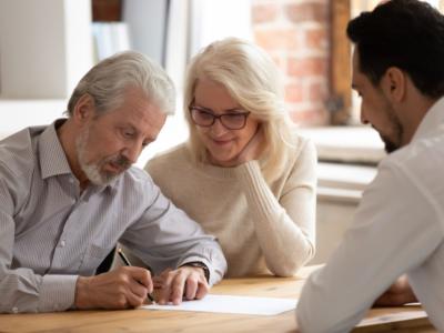 coppia anziana che firma un contratto