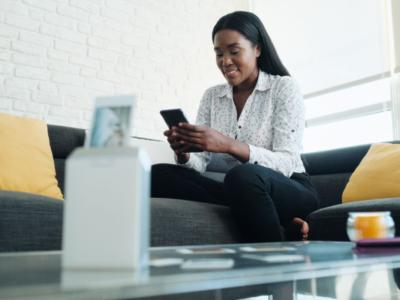 Donna che stampa una foto da smartphone con stampante portatile