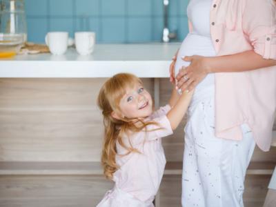 Bimba che accarezza il pancione della mamma incinta