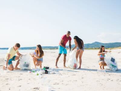 Ragazzi raccolgono rifiuti e plastica sulla spiaggia