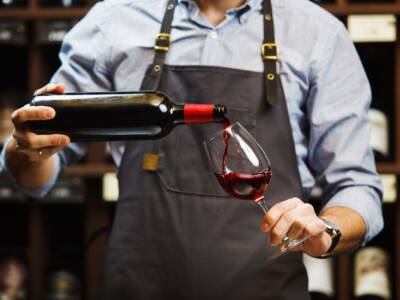 Sommelier versa vino