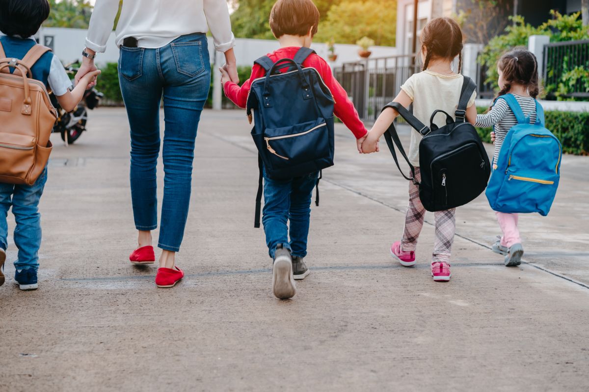 mamma accompagna bambini scuola zaini