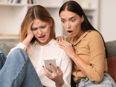 amiche leggono un messaggio e sono scioccate