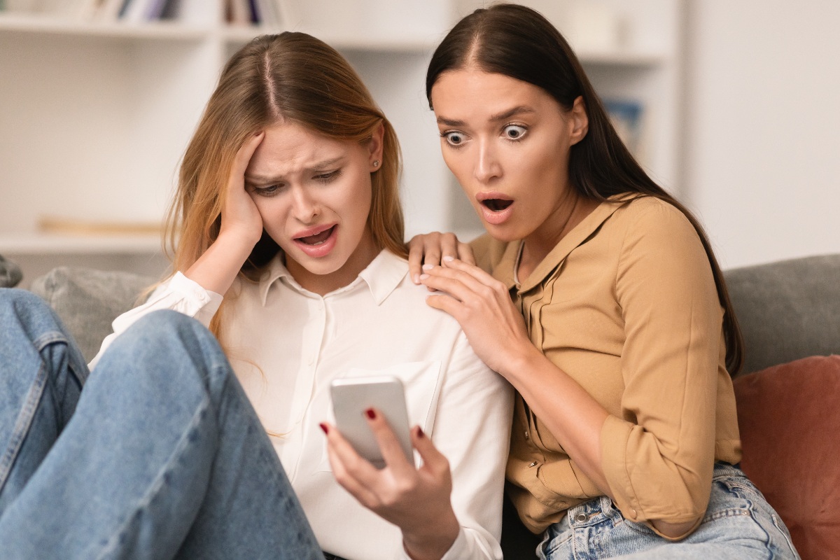 amiche leggono un messaggio e sono scioccate