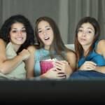 amiche che guardano un film sul divano con i popcorn