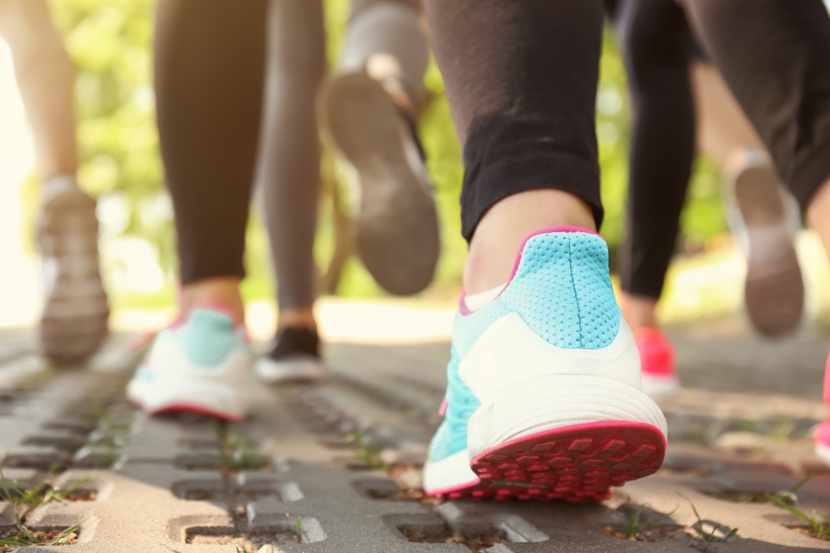 L'inquadratura si concentra sui piedi di chi cammina, con un primo piano sulle scarpe
