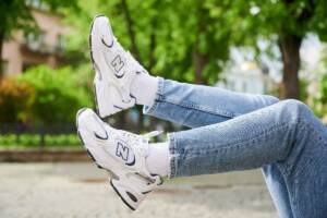 Scarpe New Balance indossate con calze bianche e jeans