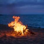 Atmosfera al tramonto con falò in riva al mare