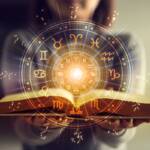 Una persona tiene aperto un libro sull’astrologia