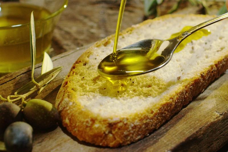 Olio di oliva versato su una fetta di pane