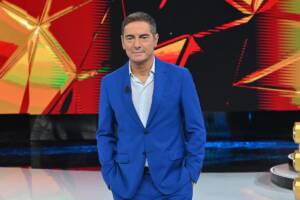 Marco Liorni con un completo blu durante un suo programma