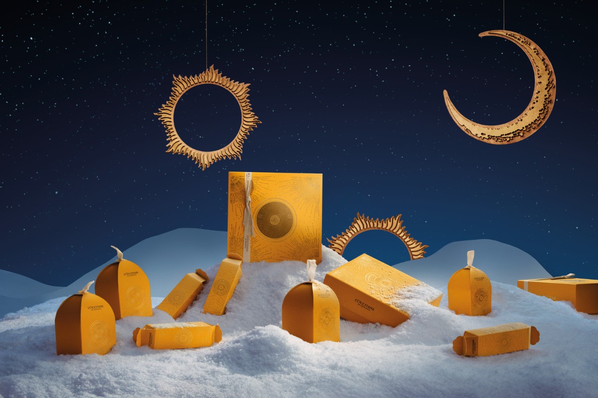 Cofanetti regalo L’Occitane en Provence, con sole e luna che risaltano in un cielo blu sullo sfondo.