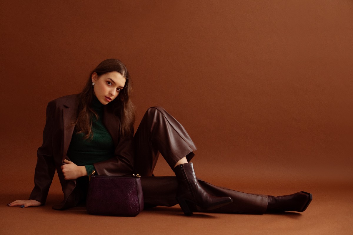 Ragazza indossa un completo in finta pelle bordeaux, elegante e perfetto per la stagione autunno/inverno.
