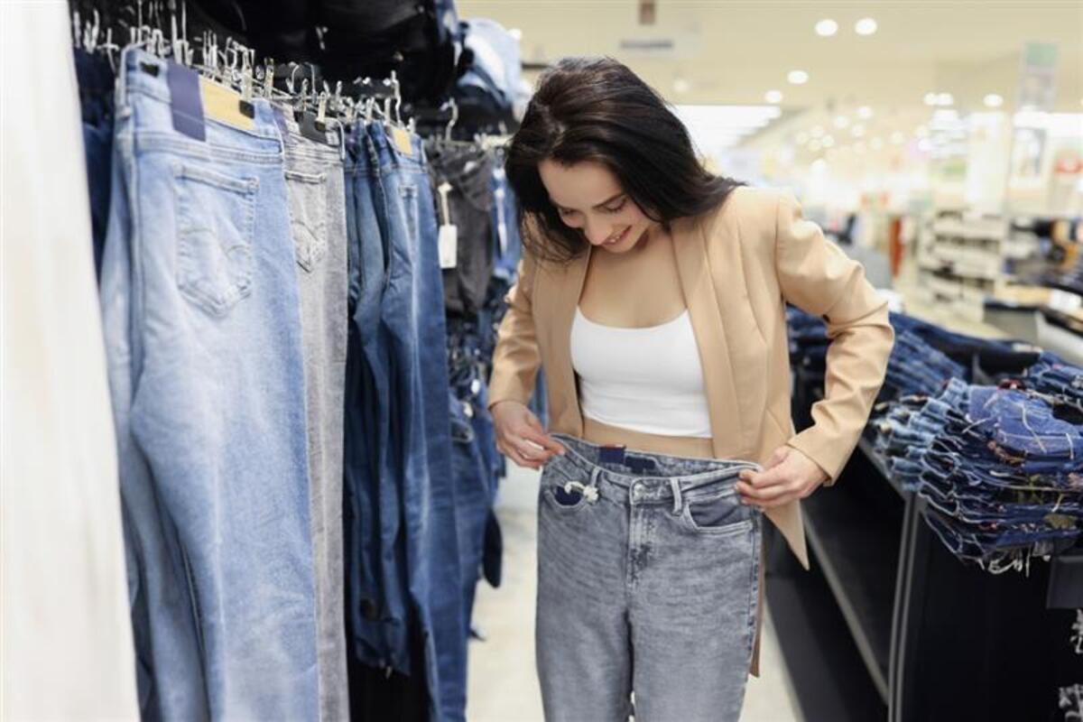 Ragazza si prova i jeans mentre fa shopping
