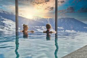 Momento di relax per due donne in piscina con vista panoramica sulle montagne.