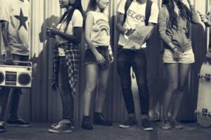 Gruppo di ragazzi con skateboard e radio, stile anni '90.