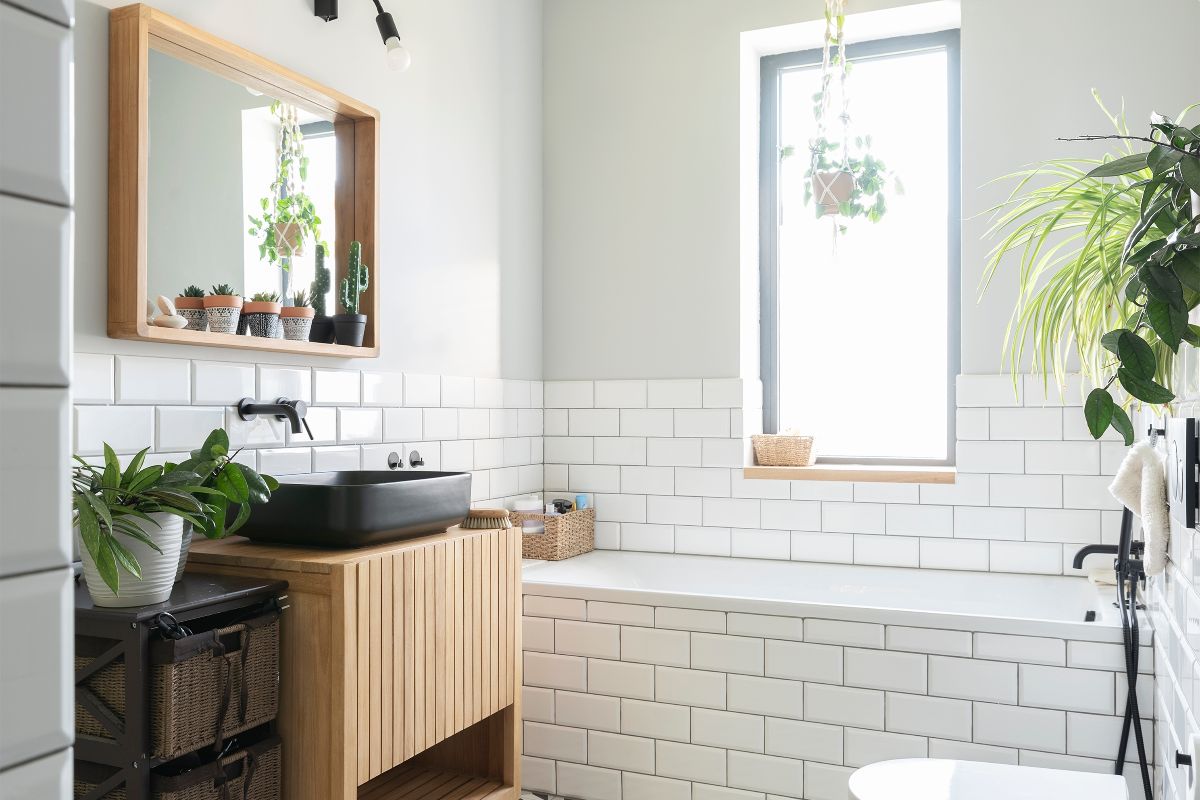 Bagno moderno con piastrelle bianche e dettagli in legno e nero.