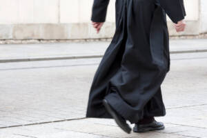 Un prete con la sua veste nera che cammina