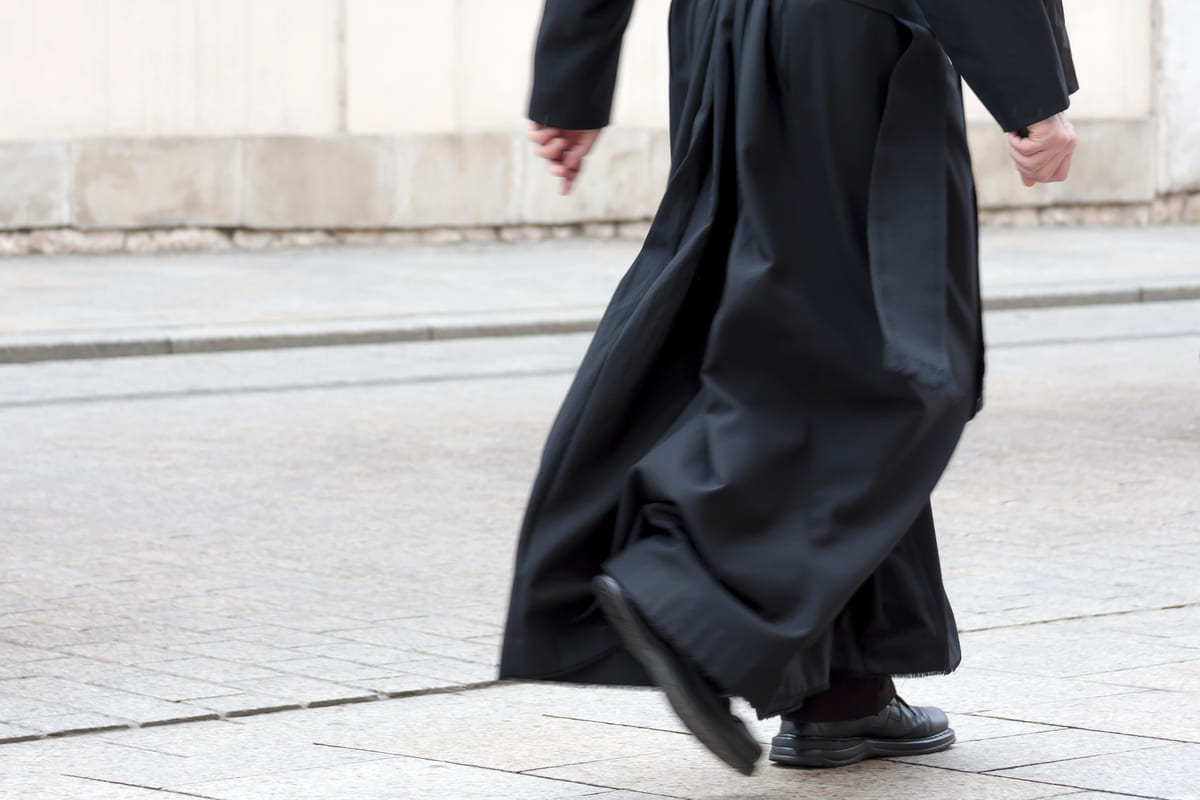 Un prete con la sua veste nera che cammina