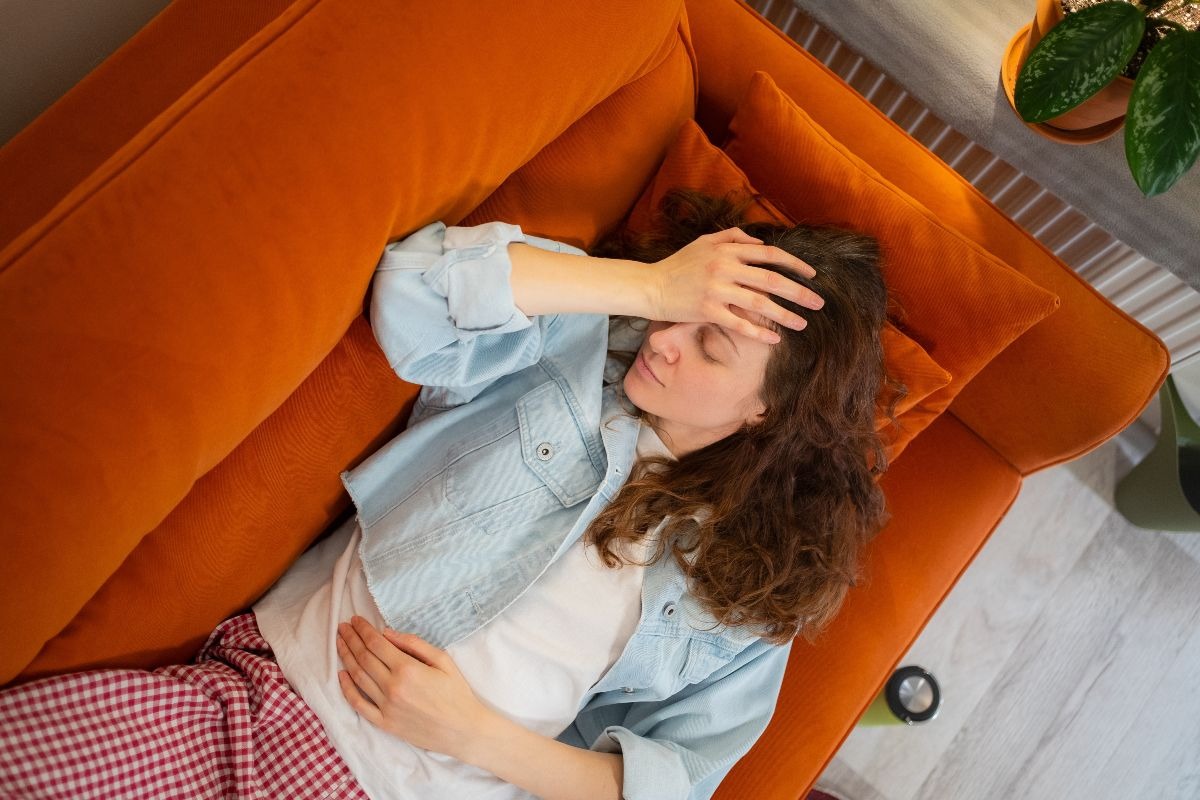Una donna malata sul divano arancione
