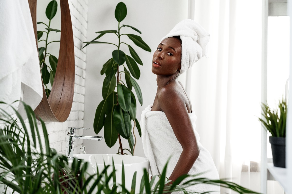 Ragazza in un bagno moderno circondata da rigogliose piante.