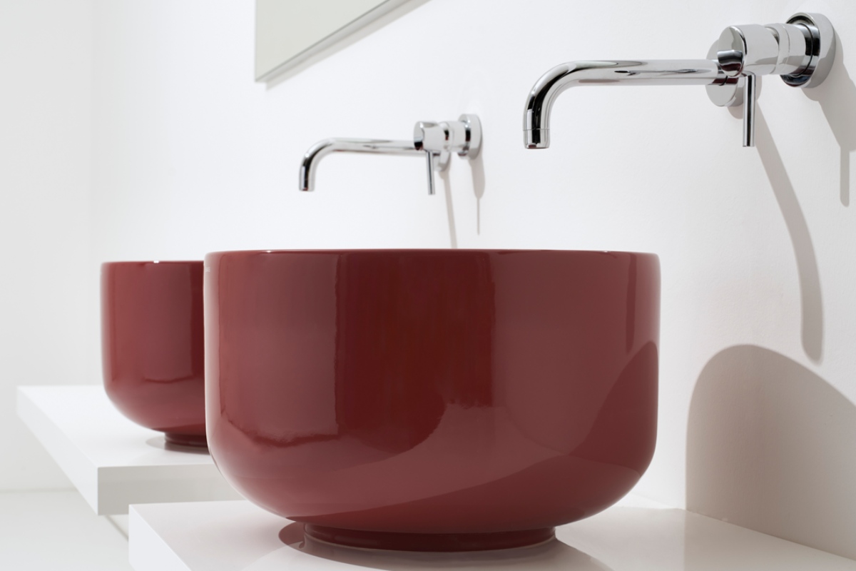 Lavabo da appoggio bordeaux con rubinetto argento.