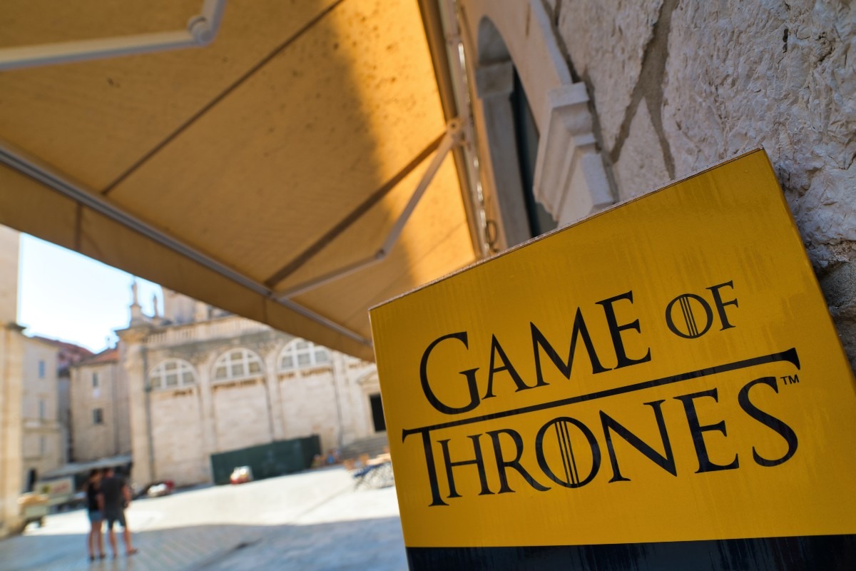 Cartellone della popolare serie TV Il Trono di Spade che invita i turisti a visitare i luoghi delle riprese a Dubrovnik