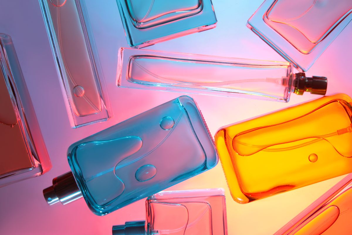 Flaconi di profumo in vetro colorato disposti su un piano.