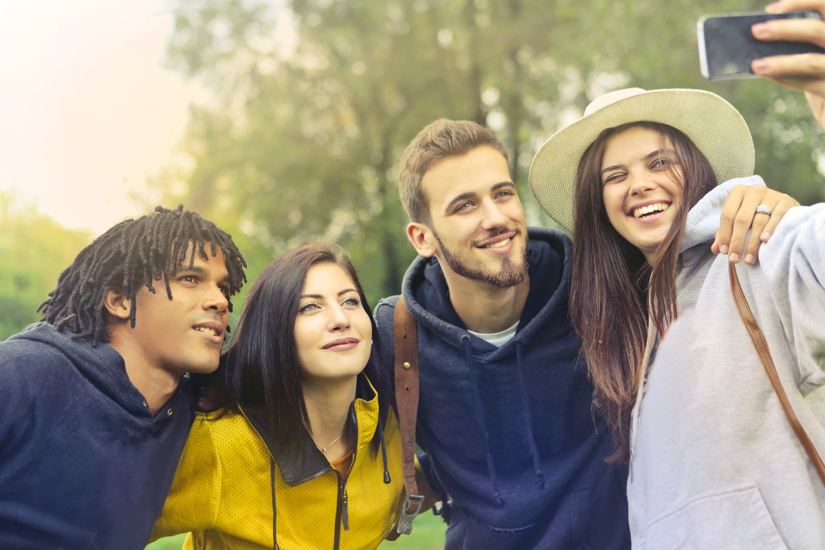 Gruppo di amici sorridenti mentre scattano un selfie.