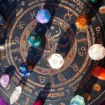 Tavola decorativa con i simboli dei segni zodiacali e cristalli colorati.