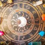 Tavola decorativa con i simboli dei segni zodiacali e cristalli colorati.
