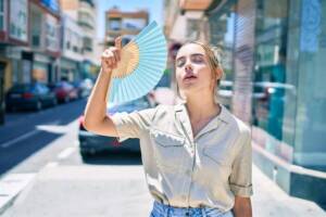 Ragazza accaldata si sventola con un ventaglio