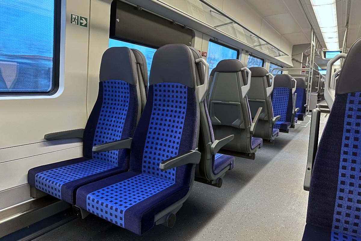 Interno di un treno regionale con sedili blu
