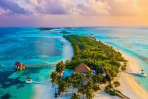 Un resort di lusso su un'isola delle Maldive circondata dal mare.