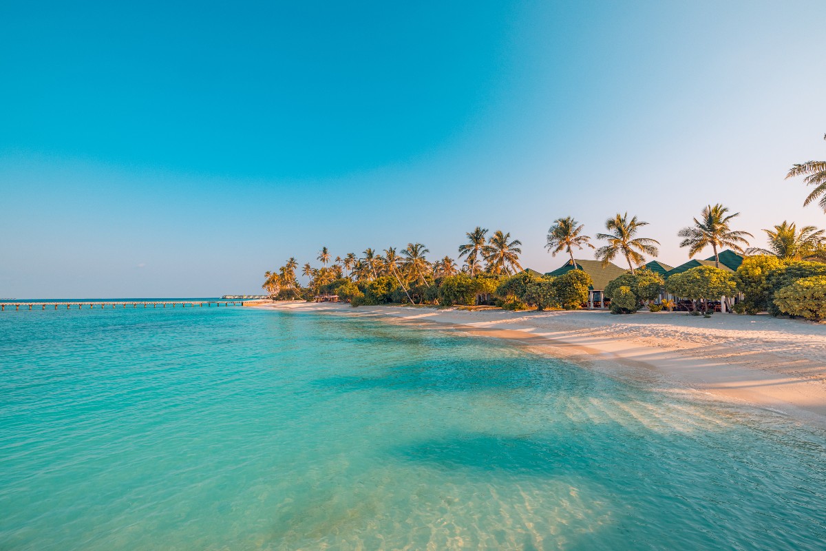 Il mare cristallino e la spiaggia di un'isola tropicale alle Maldive.