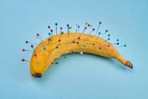 Una banana con spilli colorati