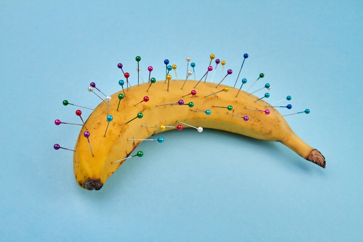 Una banana con spilli colorati