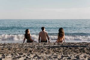 Amici in spiaggia guardano il mare