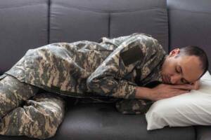 Uomo soldato che dorme sul letto
