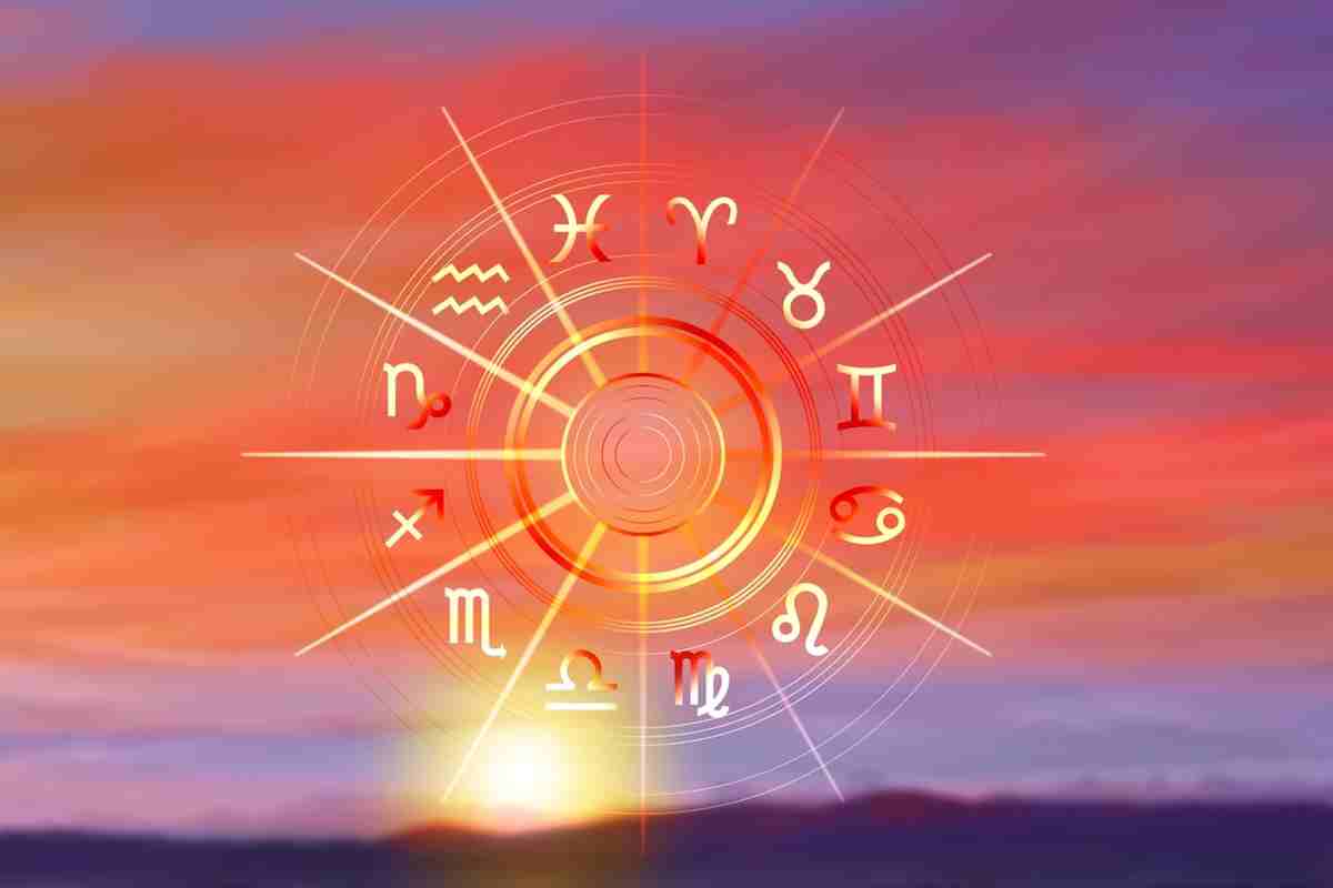 Ruota zodiacale con i dodici segni dell’oroscopo che risplendono alla luce del sole su uno sfondo di cielo dorato al tramonto